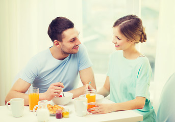 Image showing smiling couple having breakfast at home