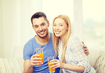 Image showing smiling happy couple at home drinking juice