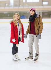 Image showing happy couple holding hands on skating rink