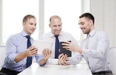 Image showing three smiling businessmen with tablet pc in office