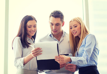 Image showing business team looking at clipboard