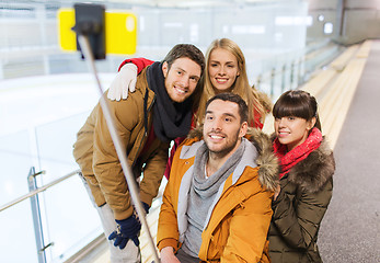 Image showing happy friends with smartphone on skating rink
