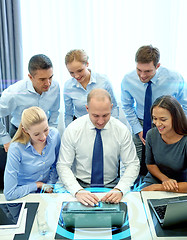 Image showing smiling business people with laptop in office