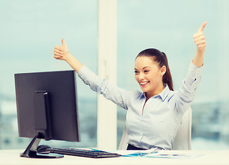 Image showing woman with computer, papers showing thumbs up