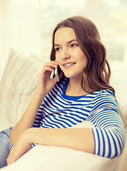 Image showing smiling teenage girl with smartphone at home