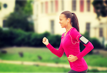 Image showing smiling young woman running outdoors