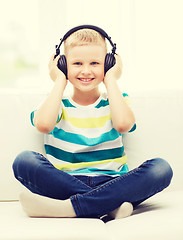 Image showing smiling little boy with headphones at home