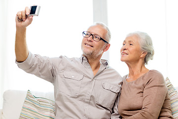 Image showing happy senior couple with camera at home