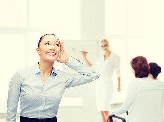 Image showing smiling businesswoman listening gossig