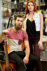 Image showing couple of musicians with guitar at music store