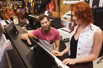 Image showing man and woman playing piano at music store