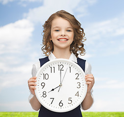 Image showing smiling girl holding big clock