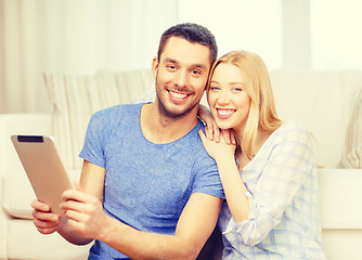 Image showing smiling happy couple with tablet pc at home