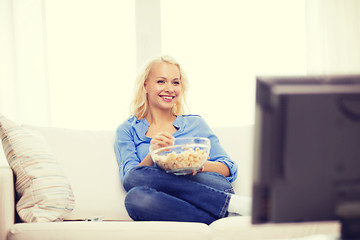Image showing young girl with popcorn watching movie at home