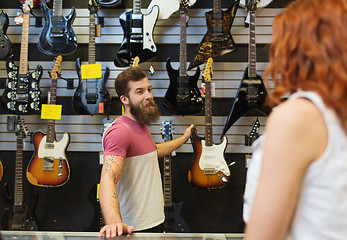 Image showing assistant showing customer guitar at music store