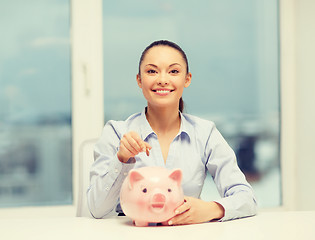 Image showing smiling woman with piggy bank and cash money