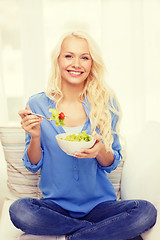 Image showing smiling young woman with green salad at home