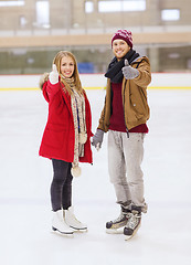 Image showing happy couple holding hands on skating rink