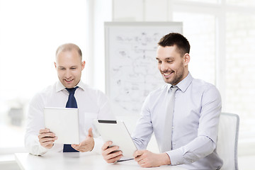 Image showing two smiling businessmen with tablet pc in office