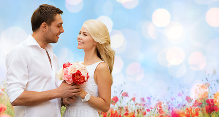 Image showing happy couple with flowers over lights background