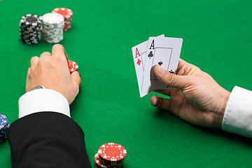 Image showing poker player with cards and chips at casino