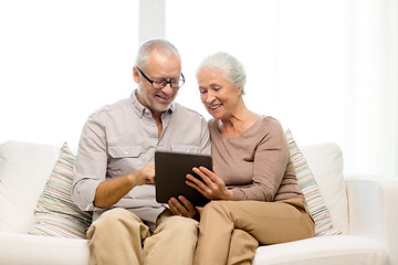 Image showing happy senior couple with tablet pc at home