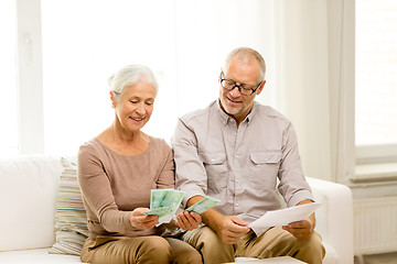 Image showing senior couple with money and calculator at home