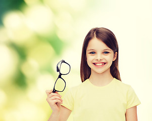 Image showing smiling cute little girl holding black eyeglasses