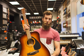 Image showing assistant or customer with guitar at music store