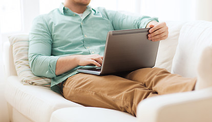 Image showing close up of man working with laptop at home