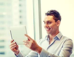 Image showing smiling businessman with tablet pc in office