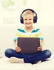 Image showing little boy with tablet pc and headphones at home