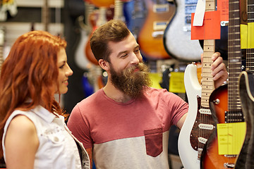 Image showing couple of musicians with guitar at music store