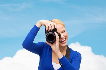 Image showing smiling woman taking picture with digital camera