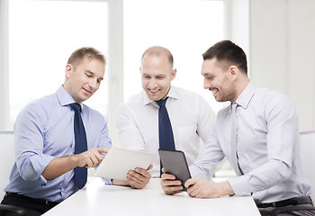 Image showing three smiling businessmen with tablet pc in office