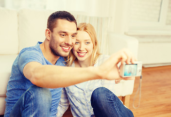 Image showing smiling couple taking picture with digital camera