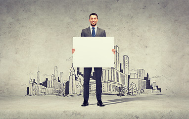 Image showing smiling businessman with white blank board