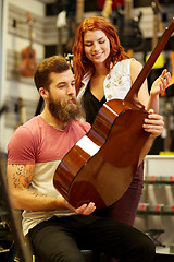 Image showing couple of musicians with guitar at music store