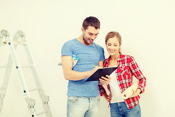 Image showing smiling couple with clipboard and wallpaper roll