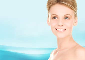 Image showing close up of smiling woman over blue background
