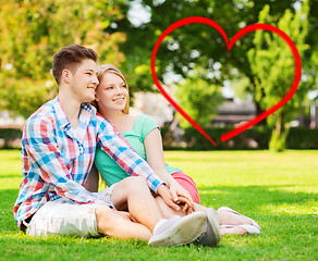 Image showing smiling couple sitting on grass in summer park