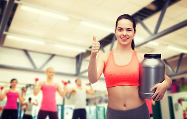 Image showing teenage girl with jar of protein showing thumbs up