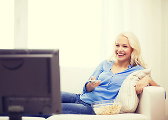 Image showing young girl with popcorn watching movie at home