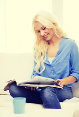 Image showing woman sitting on couch and reading magazine