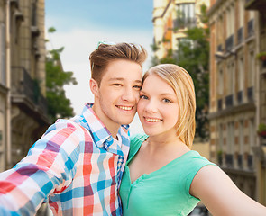 Image showing smiling couple with smartphone in city background