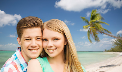 Image showing smiling couple hugging over beach background