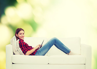 Image showing teenage girl sitting on sofa with tablet pc