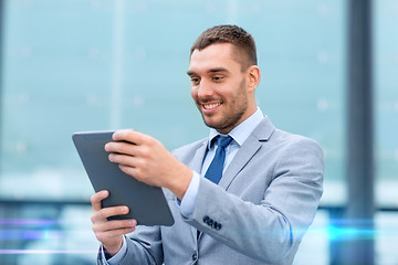 Image showing smiling businessman with tablet pc outdoors