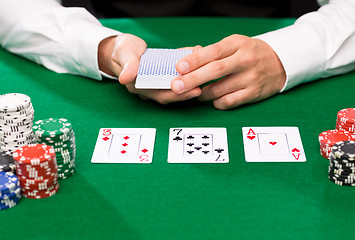 Image showing holdem dealer with playing cards and casino chips