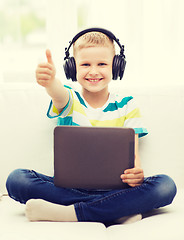 Image showing little boy with tablet pc and headphones at home